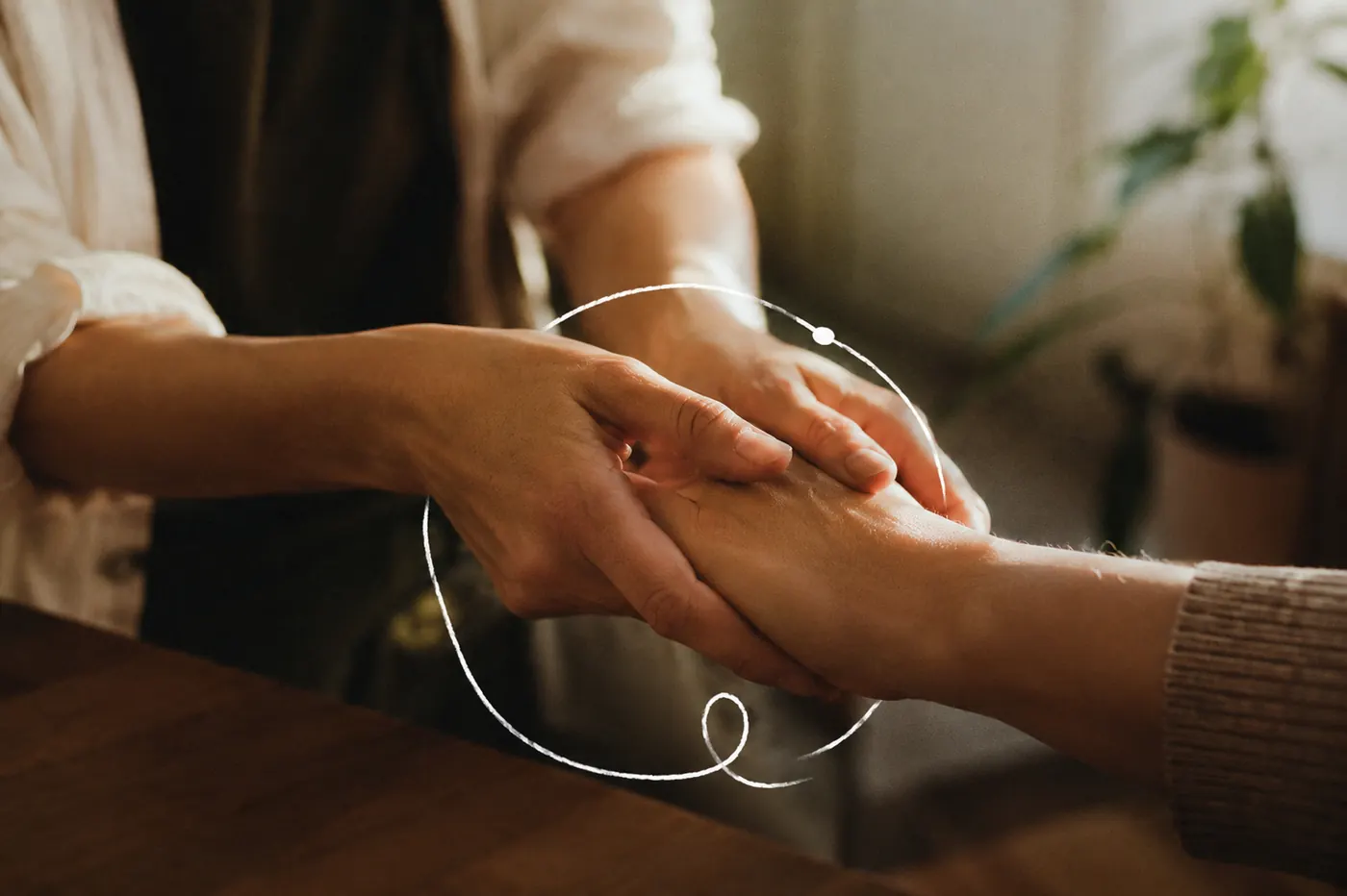 Manos de la terapeuta sosteniendo la mano de una paciente